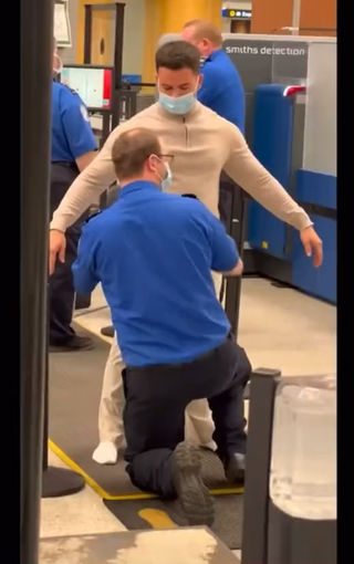 Airport security has to search this man in the back room because they didn’t believe he wasn’t carrying extra items on him person.